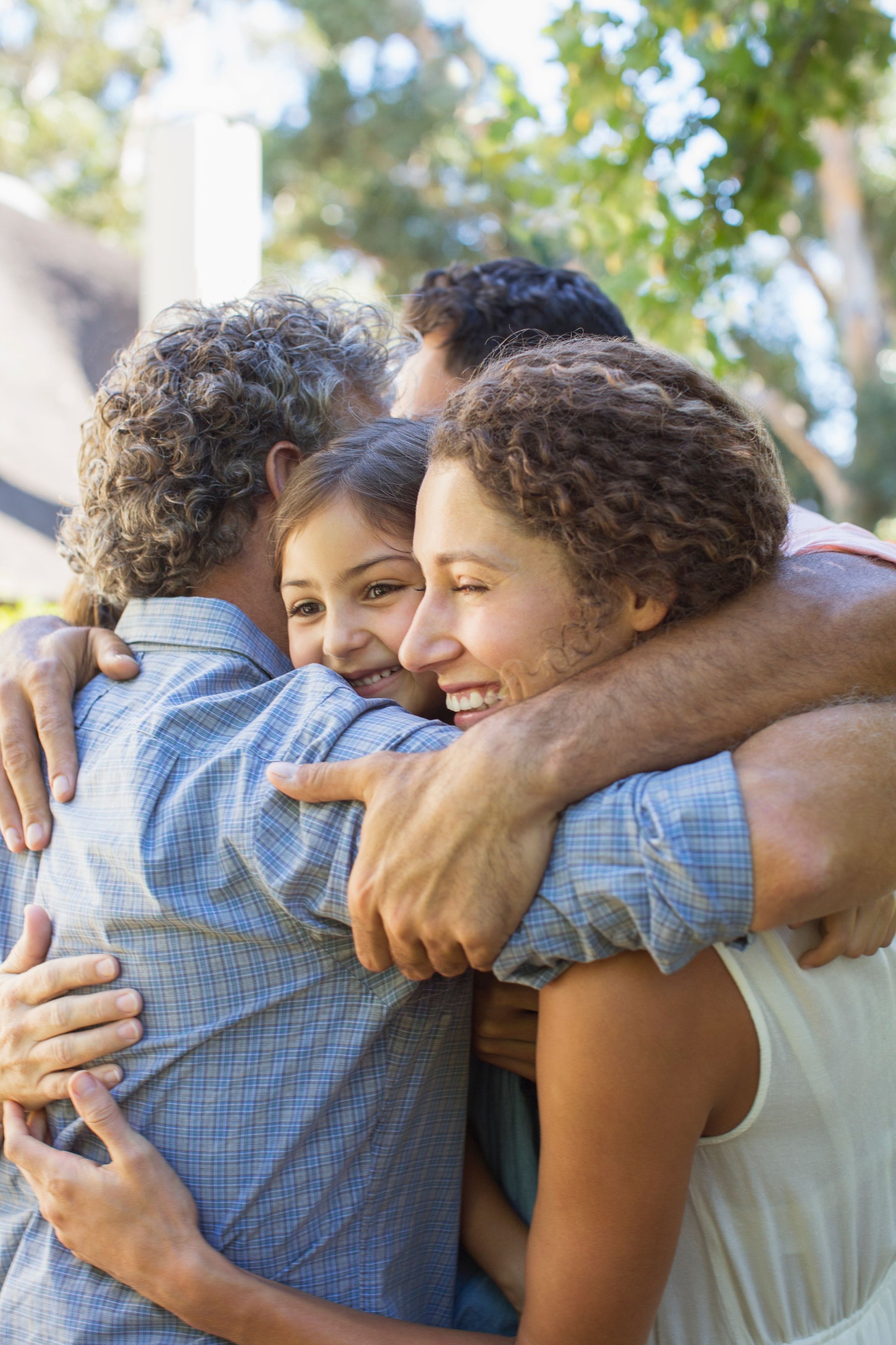 Family hugging outdoors